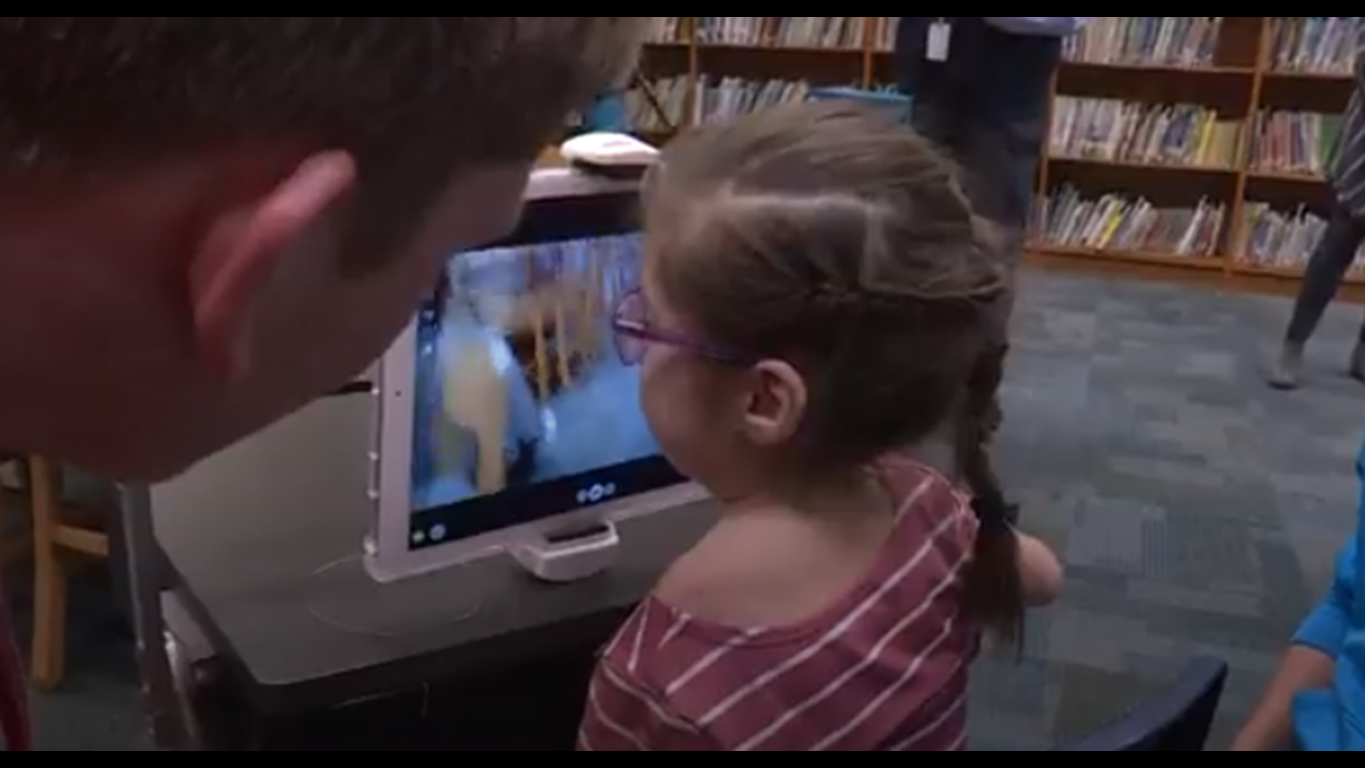 A second grader with a disability gets help around the classroom from local tech center students.