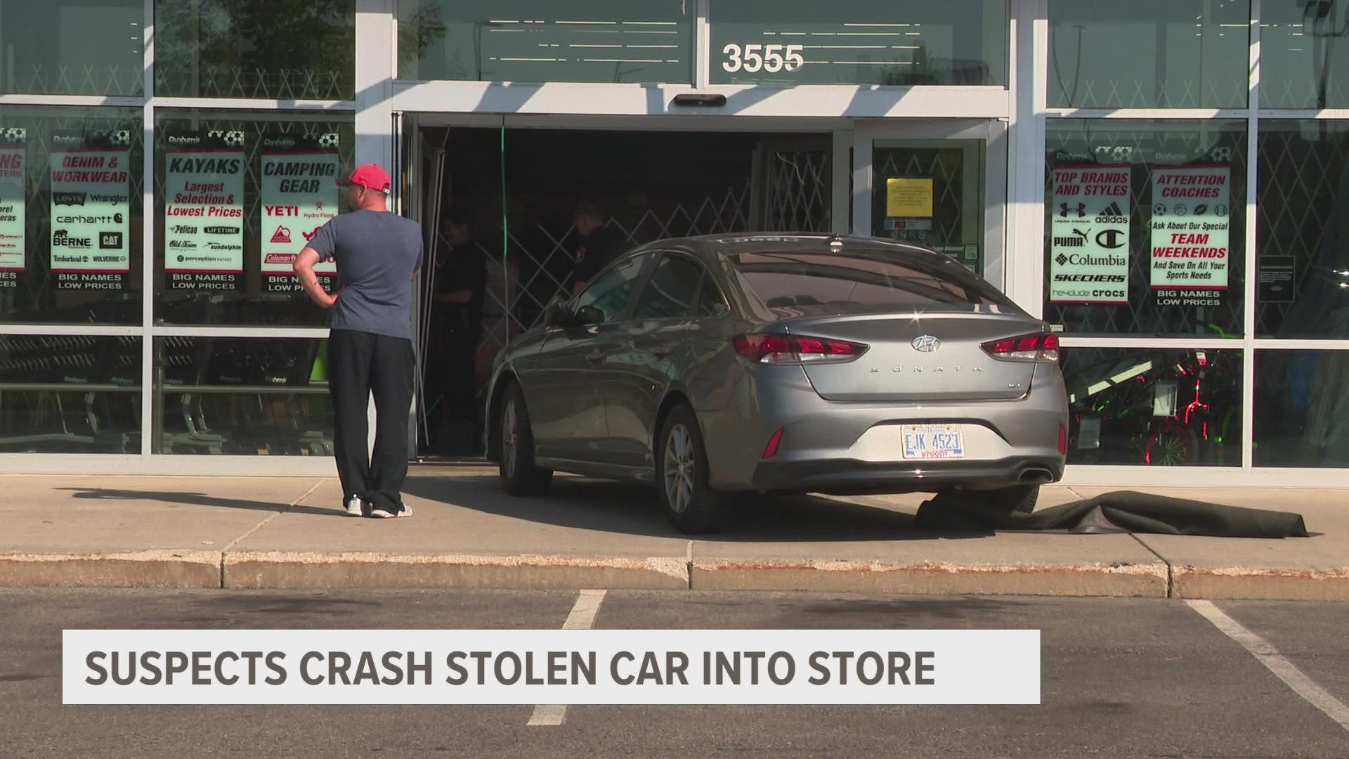 Police say four suspects fled the scene on foot after crashing a stolen vehicle into the storefront.