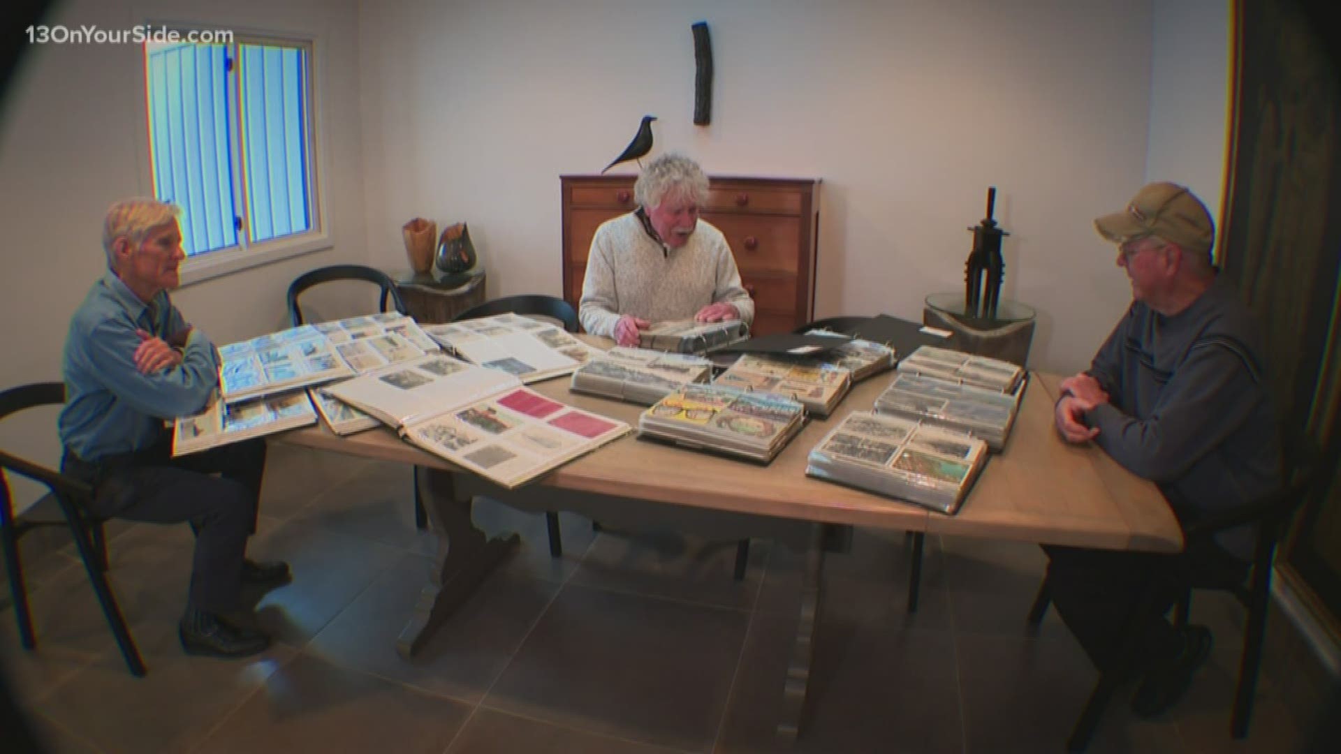 Three men are the local keepers of history with a collection of Grand Haven postcards.