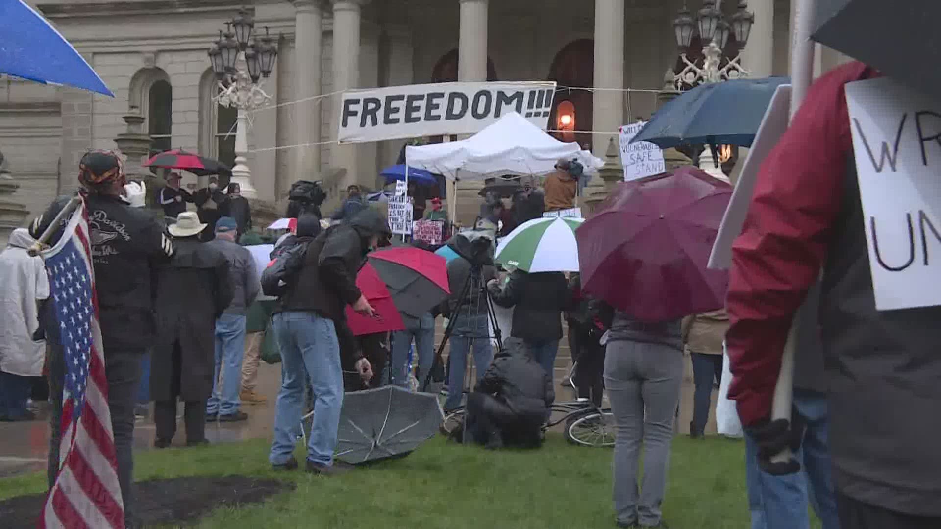 Protesters gathered in the rain at the Michigan State Capitol building Thursday, May 14 for a rally against Gov. Gretchen Whitmer's stay at home order.