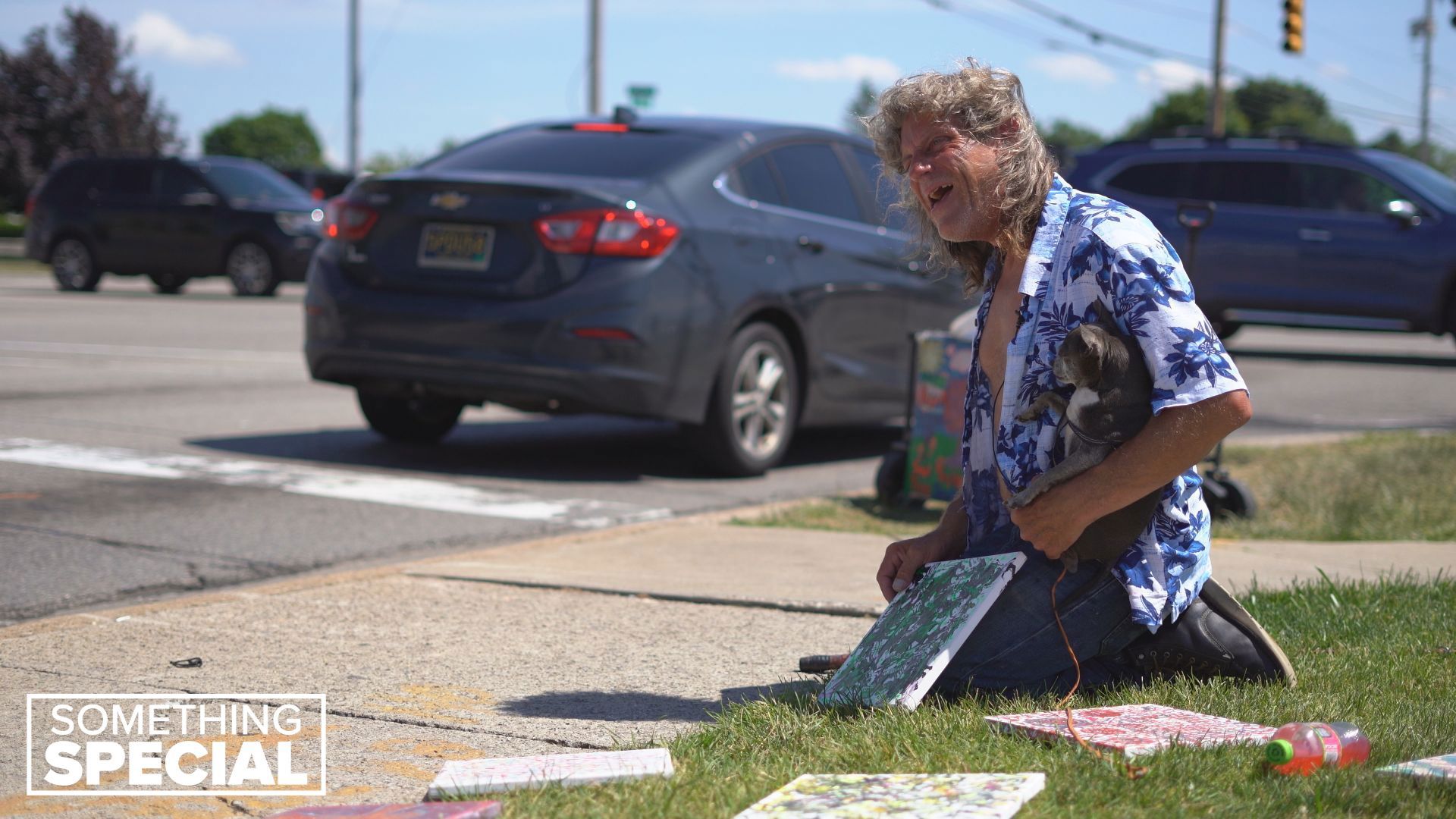 You may have noticed a man and his tiny Chihuahua setting up paintings on the corner of 28th Street and East Paris Avenue. Here's why he's making art curbside.