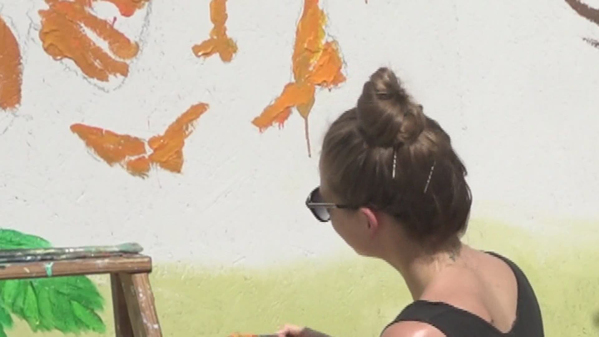 Boarded up windows on business downtown are being transformed into murals.