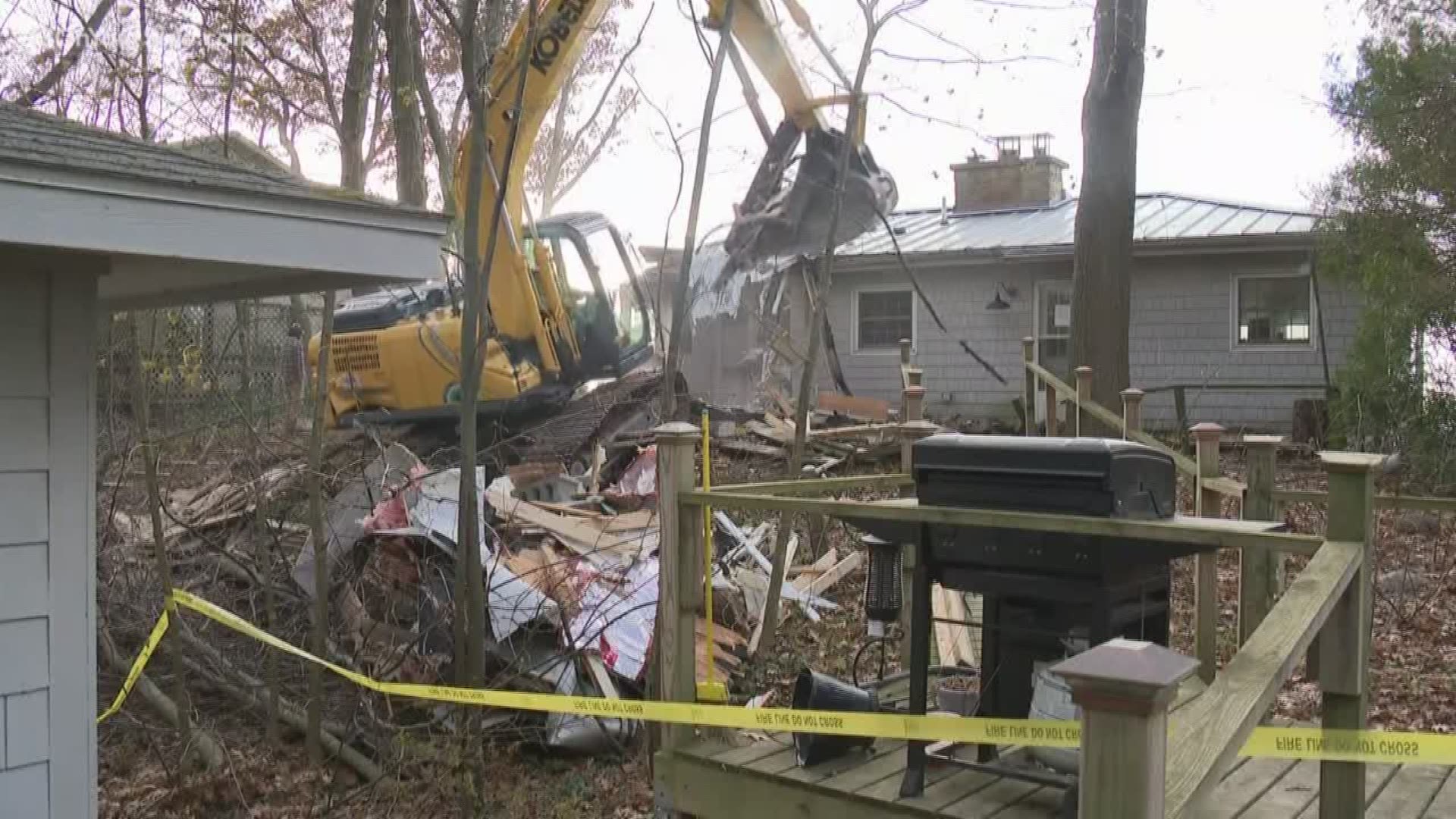 A cottage that was on the brink of falling into Lake Michigan after the bluff it sits on was eroded was demolished on Friday.